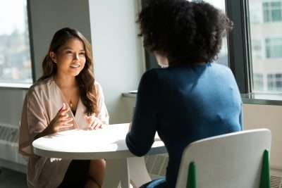 Client and psychologist sitting across from each other in a therapy session, discussing mental health in a calm, supportive environment